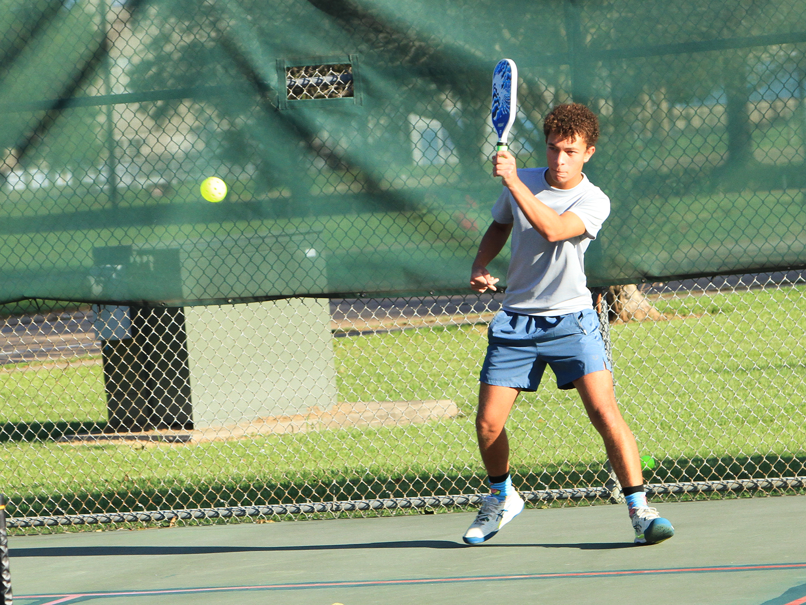 male pickleball player hitting ball
