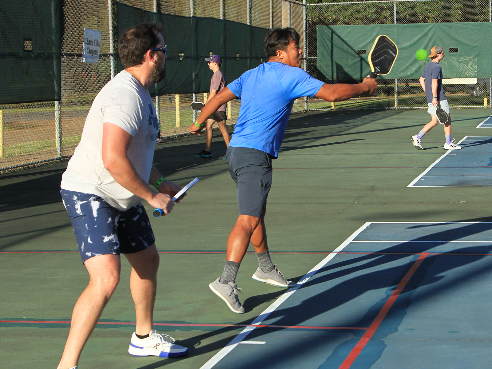 male pickleball player hitting ball