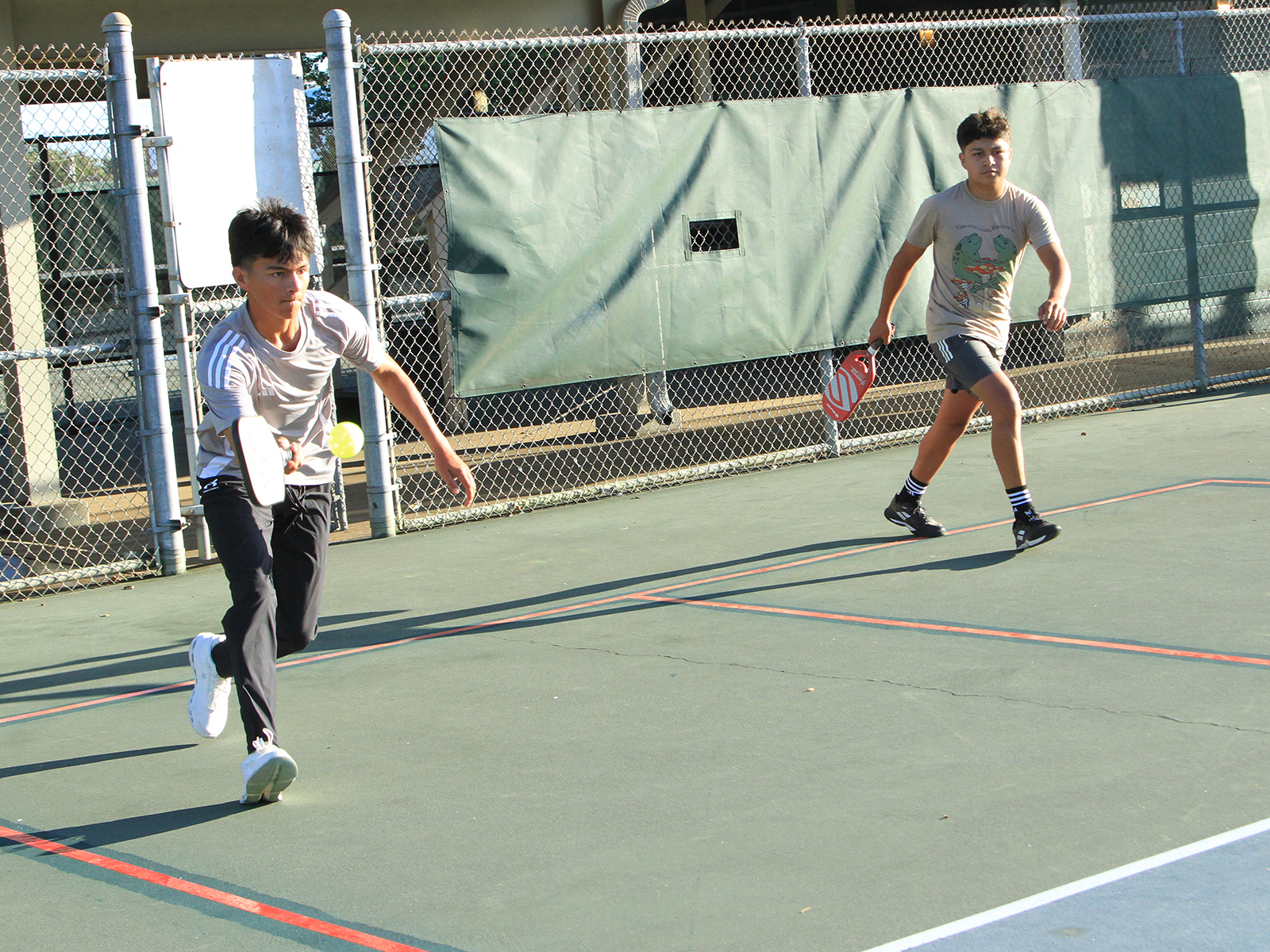 male pickleball player hitting ball