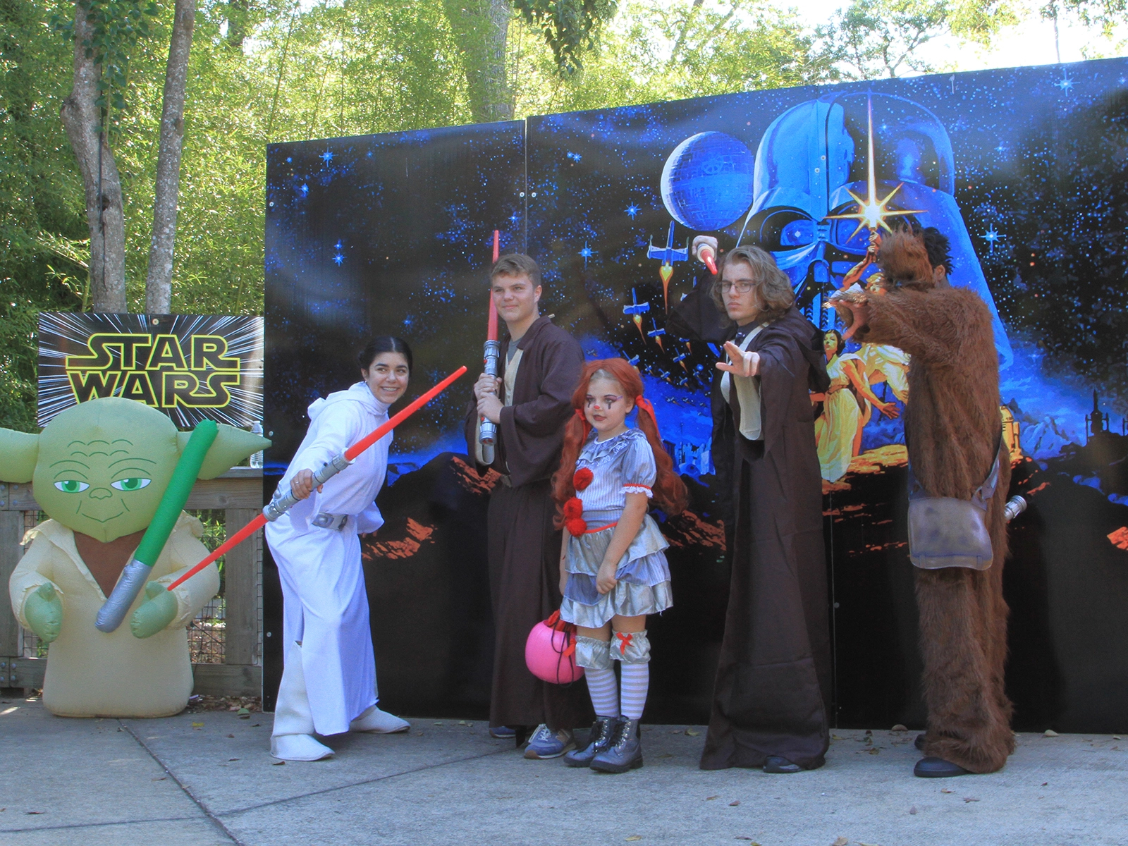students in costume posing with child